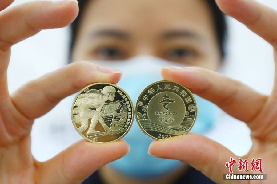 11月18日，江西南昌，銀行工作人員展示第24屆冬季奧林匹克運動會「冰上運動」普通紀念幣。圖：中新社