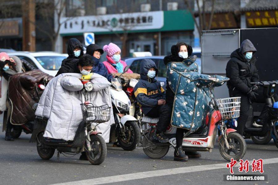 11月21日，市民「捂」裝出行。當日，內蒙古呼和浩特市迎來大風降溫天氣。圖：中新社