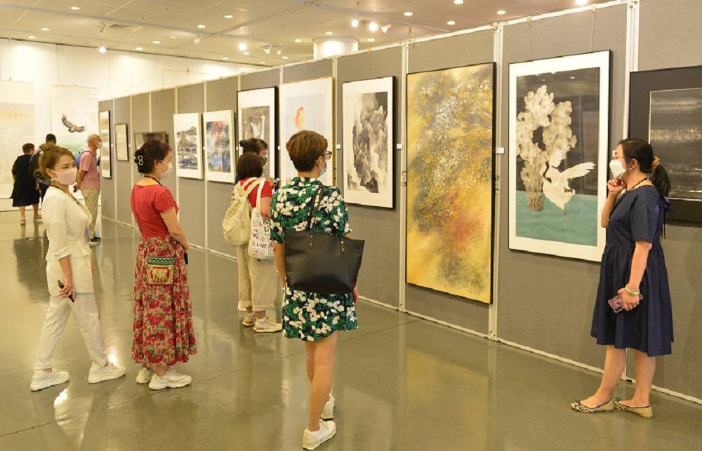 展覽現場一角，藝術家朋友和市民在欣賞畫作。